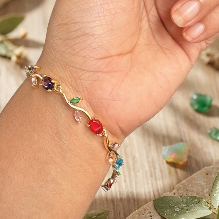 A gold leaf charm bracelet with colorful gemstone accents