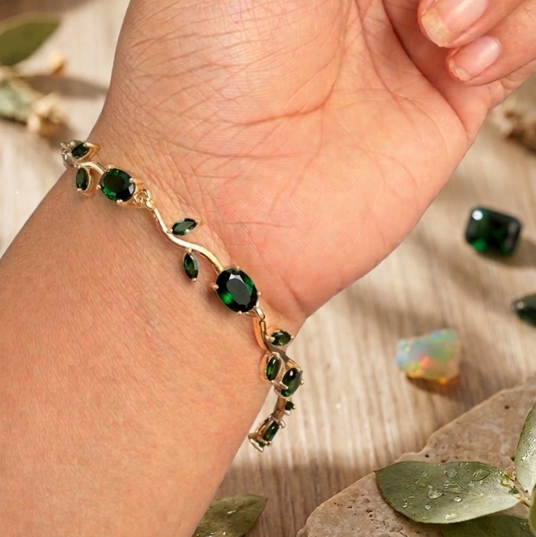 gold bracelet with green gemstone