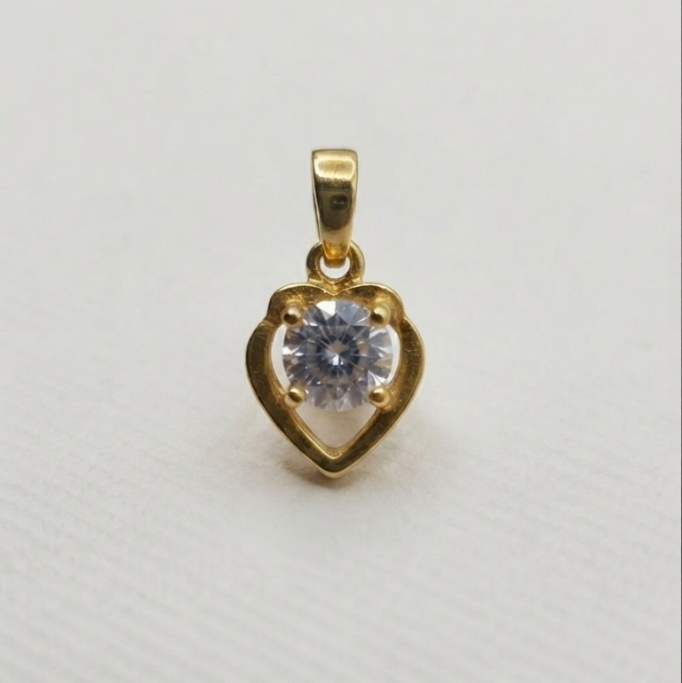 gold heart-shaped pendant with a clear heart-shaped gemstone