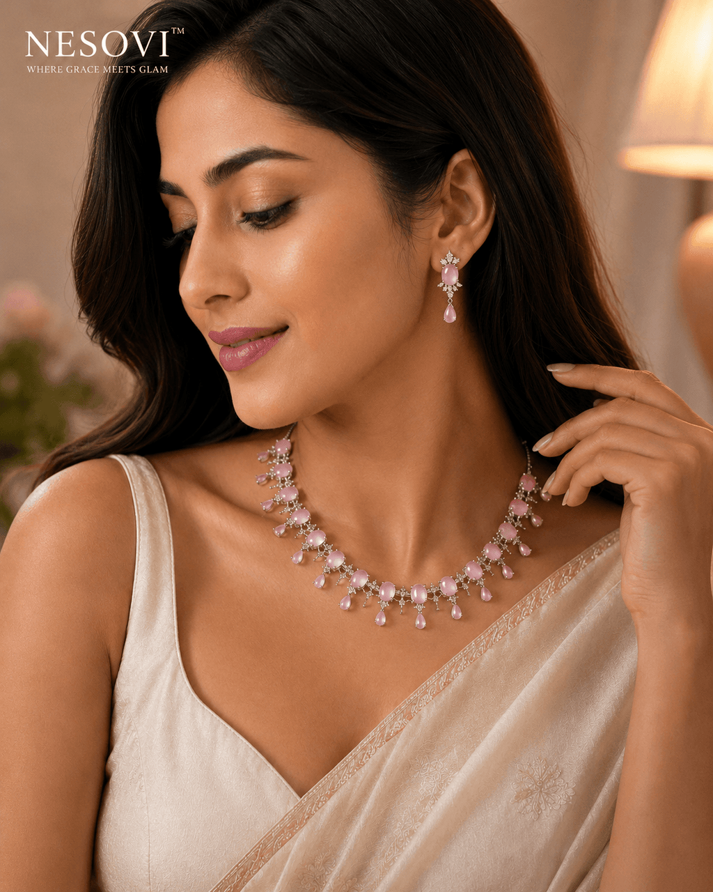 A woman wearing a pink gemstone necklace and matching drop earrings.