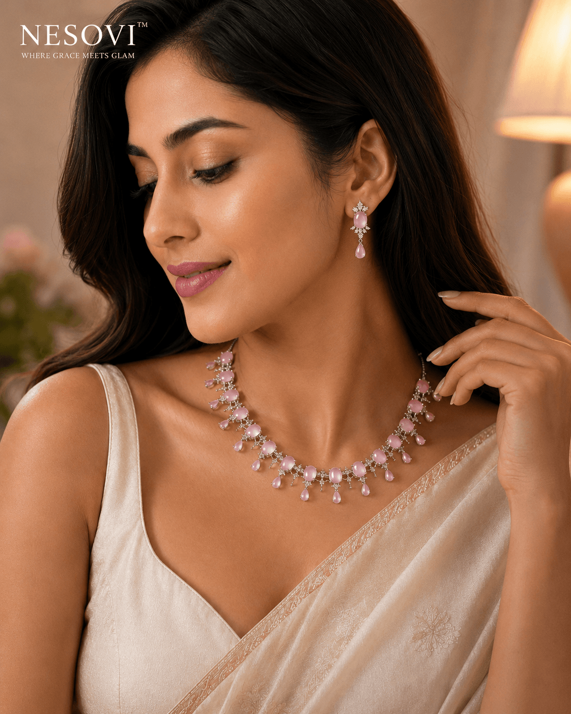 A woman wearing a pink gemstone necklace and matching drop earrings.